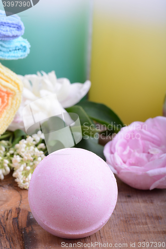 Image of sea salt, towels, aroma oil, flower and on wooden plate 