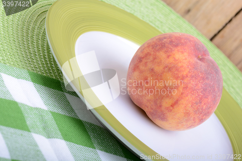 Image of fresh peaches on green plate, food concept