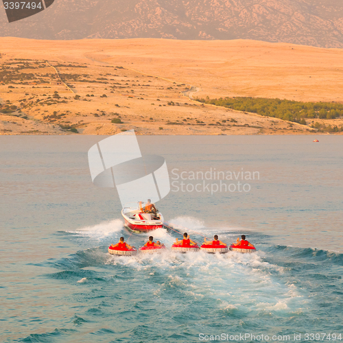 Image of Kids tube riding tawed by speedboat.