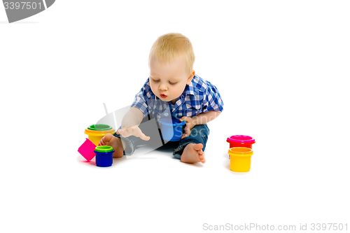 Image of baby boy on a white floor with toys