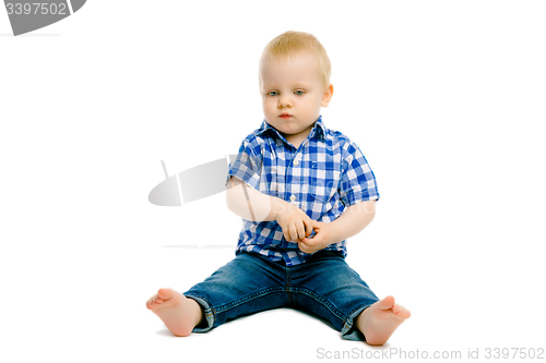 Image of boy sitting on a white floor