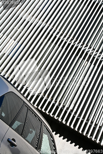 Image of Car and stripes, car parked in front of a building with striped 