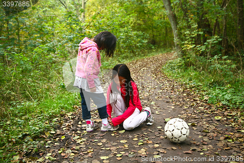 Image of Girl playing football outdoor in a forest