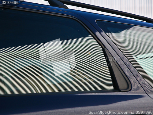 Image of Car and stripes, car parked in front of a building with striped 