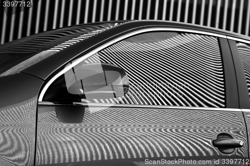 Image of Car and stripes, car parked in front of a building with striped 