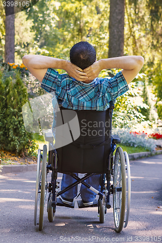 Image of young man in a wheelchair enjoying fresh air on a sunny day