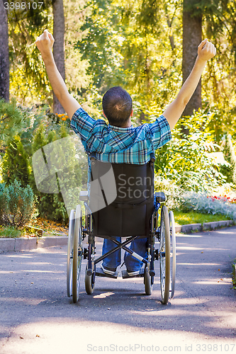 Image of young man in wheelchair with wide opened arms