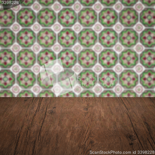 Image of Wood table top and blur vintage ceramic tile pattern wall