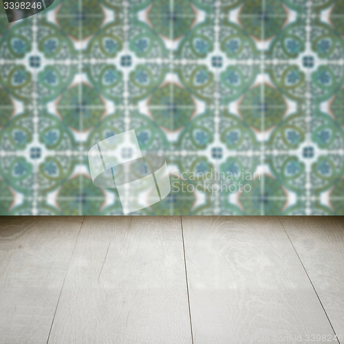 Image of Wood table top and blur vintage ceramic tile pattern wall