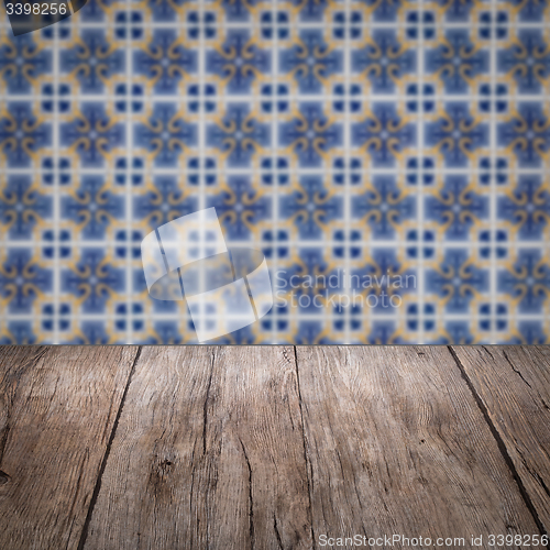 Image of Wood table top and blur vintage ceramic tile pattern wall