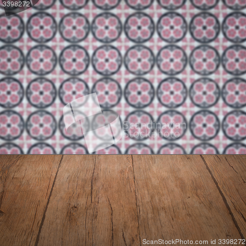 Image of Wood table top and blur vintage ceramic tile pattern wall