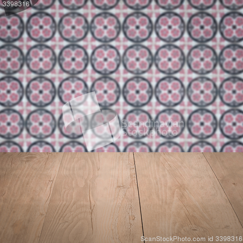 Image of Wood table top and blur vintage ceramic tile pattern wall