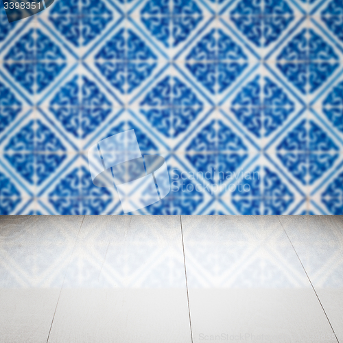 Image of Wood table top and blur vintage ceramic tile pattern wall