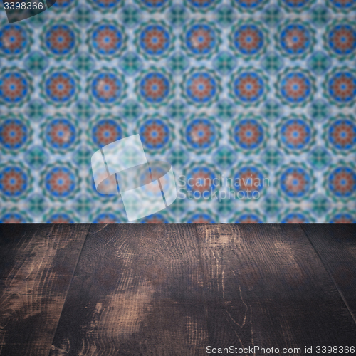 Image of Wood table top and blur vintage ceramic tile pattern wall