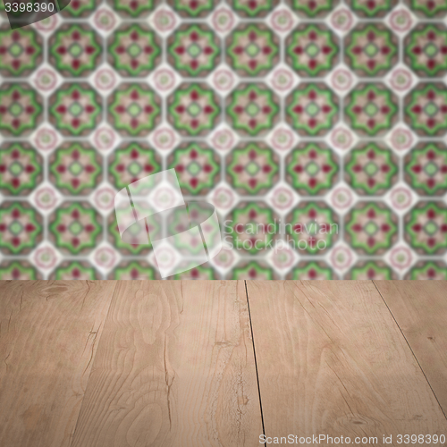 Image of Wood table top and blur vintage ceramic tile pattern wall