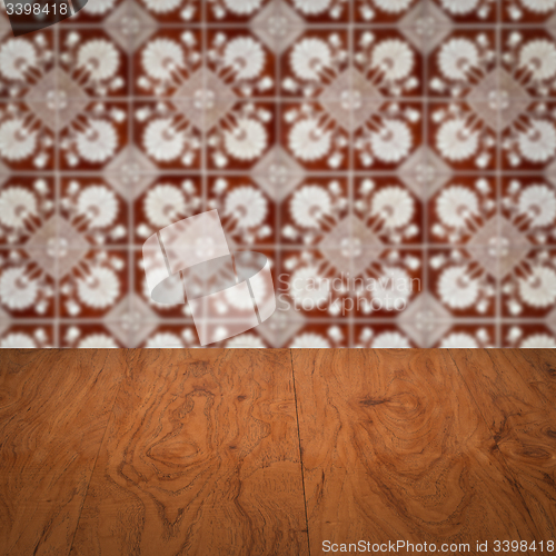 Image of Wood table top and blur vintage ceramic tile pattern wall