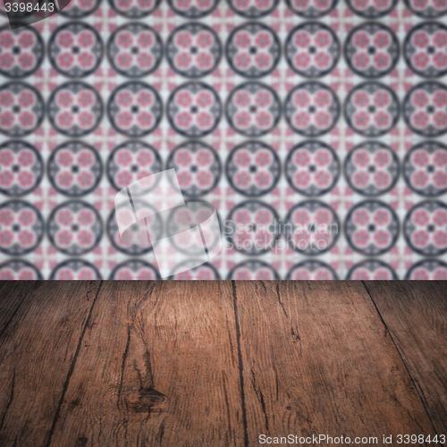 Image of Wood table top and blur vintage ceramic tile pattern wall