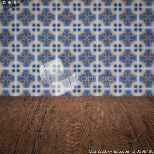 Image of Wood table top and blur vintage ceramic tile pattern wall