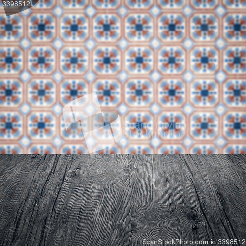 Image of Wood table top and blur vintage ceramic tile pattern wall