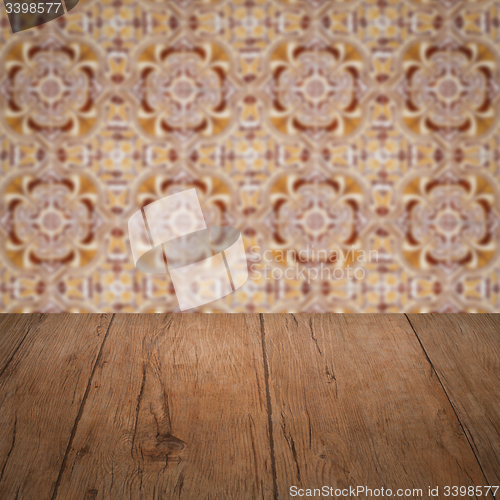 Image of Wood table top and blur vintage ceramic tile pattern wall
