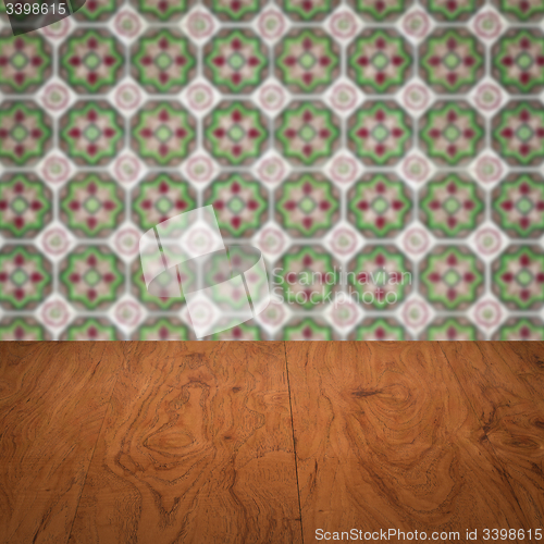 Image of Wood table top and blur vintage ceramic tile pattern wall