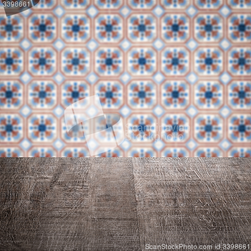 Image of Wood table top and blur vintage ceramic tile pattern wall