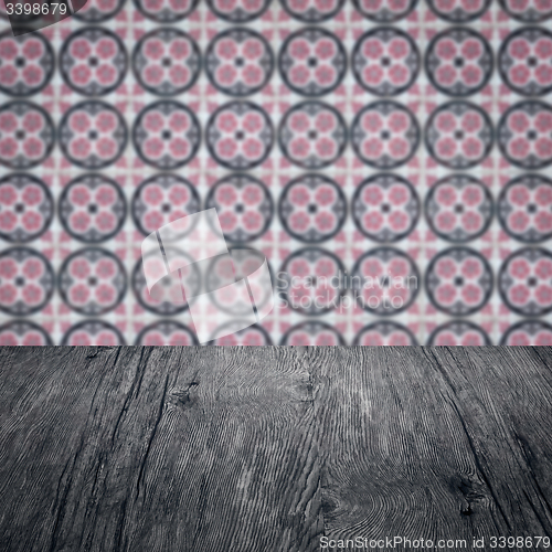 Image of Wood table top and blur vintage ceramic tile pattern wall
