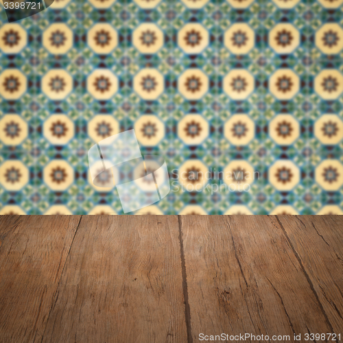 Image of Wood table top and blur vintage ceramic tile pattern wall