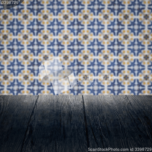 Image of Wood table top and blur vintage ceramic tile pattern wall