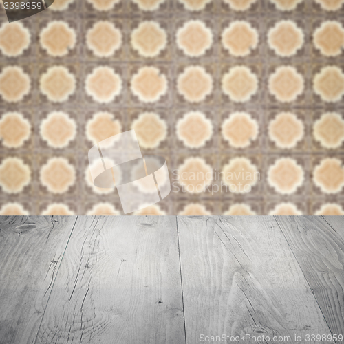 Image of Wood table top and blur vintage ceramic tile pattern wall