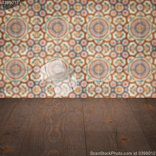 Image of Wood table top and blur vintage ceramic tile pattern wall