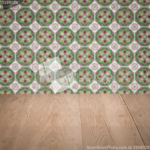 Image of Wood table top and blur vintage ceramic tile pattern wall