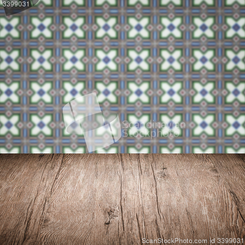 Image of Wood table top and blur vintage ceramic tile pattern wall