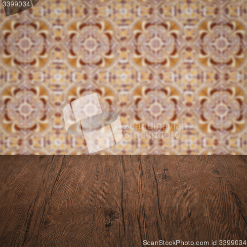 Image of Wood table top and blur vintage ceramic tile pattern wall