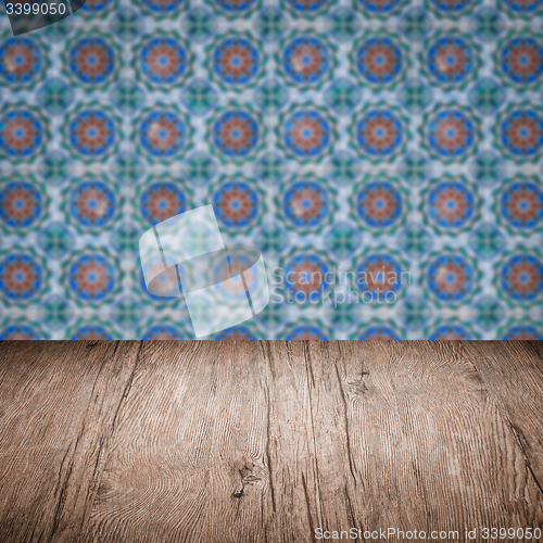 Image of Wood table top and blur vintage ceramic tile pattern wall