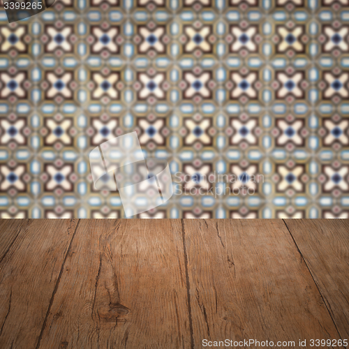 Image of Wood table top and blur vintage ceramic tile pattern wall