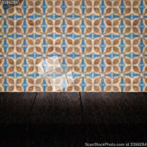 Image of Wood table top and blur vintage ceramic tile pattern wall