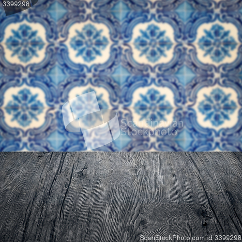 Image of Wood table top and blur vintage ceramic tile pattern wall