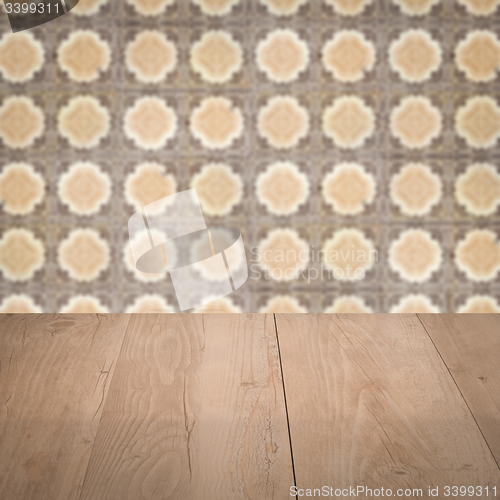 Image of Wood table top and blur vintage ceramic tile pattern wall