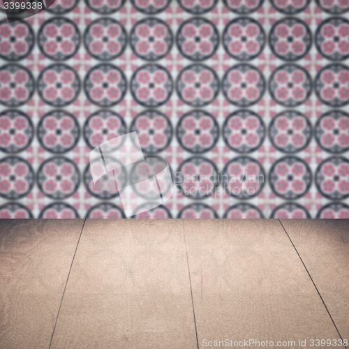 Image of Wood table top and blur vintage ceramic tile pattern wall