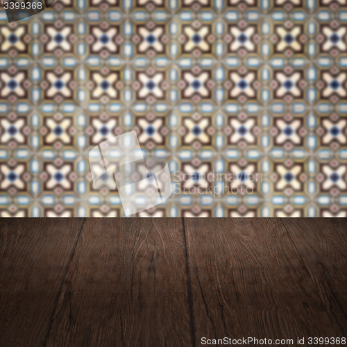 Image of Wood table top and blur vintage ceramic tile pattern wall