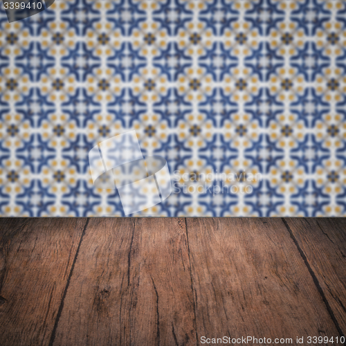Image of Wood table top and blur vintage ceramic tile pattern wall