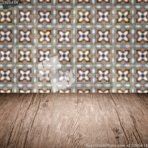 Image of Wood table top and blur vintage ceramic tile pattern wall