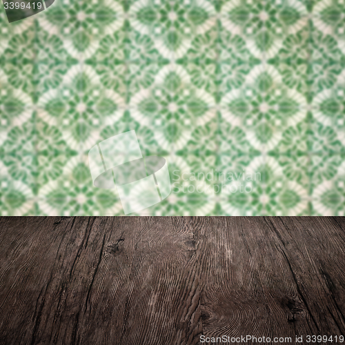 Image of Wood table top and blur vintage ceramic tile pattern wall