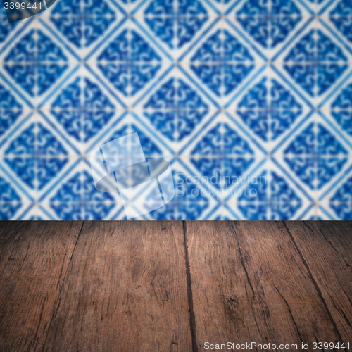 Image of Wood table top and blur vintage ceramic tile pattern wall