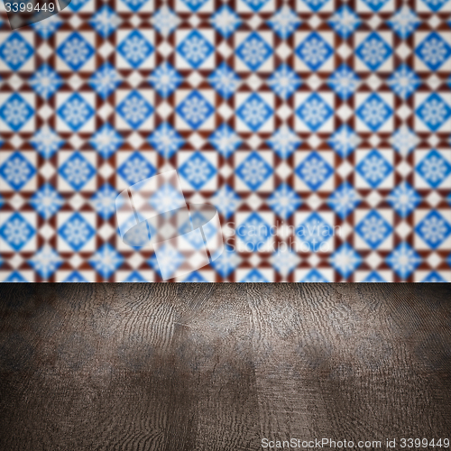 Image of Wood table top and blur vintage ceramic tile pattern wall