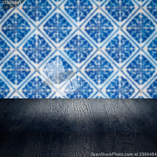 Image of Wood table top and blur vintage ceramic tile pattern wall