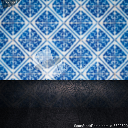 Image of Wood table top and blur vintage ceramic tile pattern wall