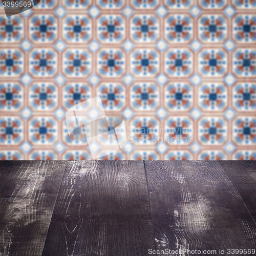 Image of Wood table top and blur vintage ceramic tile pattern wall