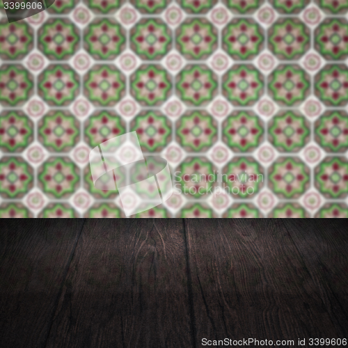 Image of Wood table top and blur vintage ceramic tile pattern wall